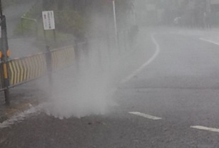 マンホールから水が噴き出している現象の写真