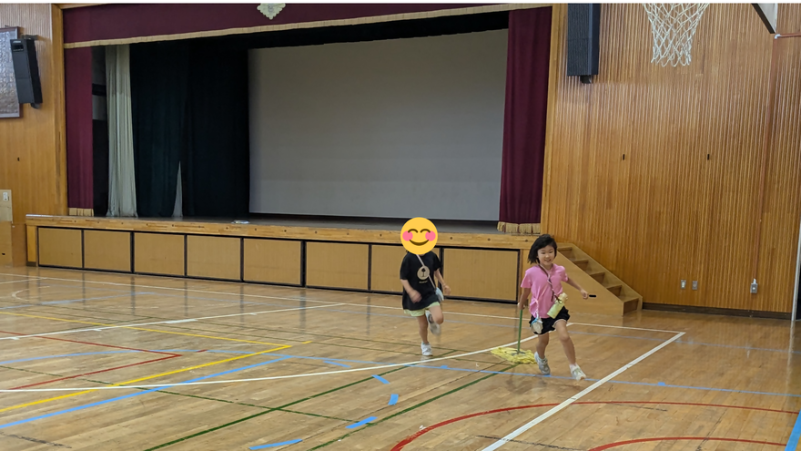 片付けの際にモップ掛け競争をする子どもの写真