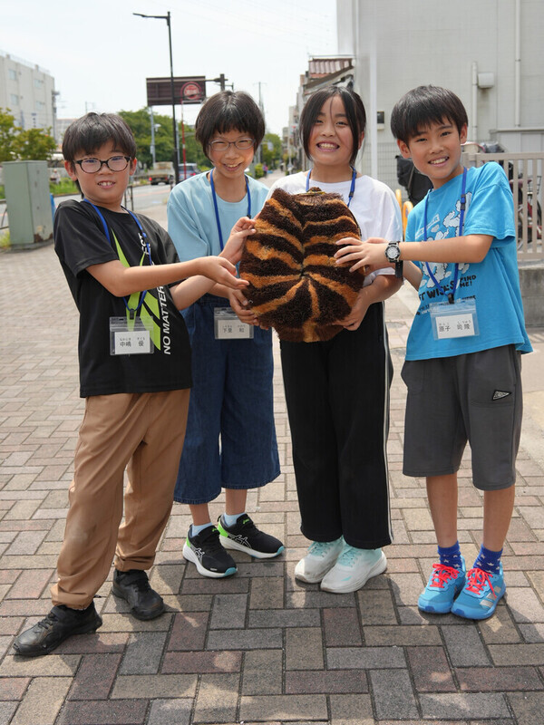 たわしを持った子供広報員